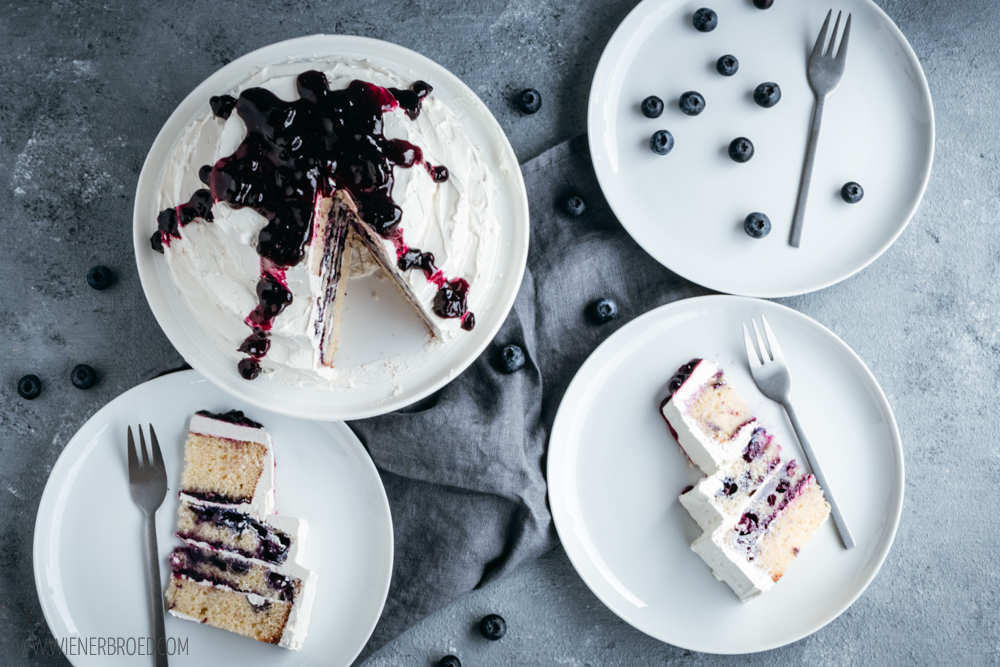 Blaubeer-Torte mit weißem Schokoladenfrosting, saftiger Rührteig mit Blaubeeren umhüllt von leckerem Frosting mit weißer Schokolade als kleine mehrstöckige Torte / Blueberry cake with white chocolate frosting [wienerbroed.com]