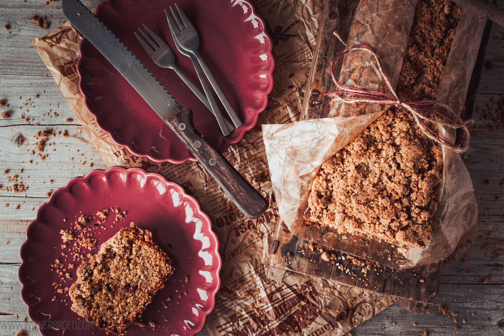 Top view Bananenbrot mit Streuseln, zwei rote Teller mit Kuchengabeln und einem Brotmesser