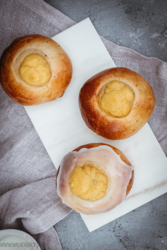 Skoleboller oder Skolebrød, norwegische Hefeteilchen mit einem Hauch Kardamom, gefüllt mit Vanillecreme und obendrauf Zuckerguss und Kokos / Skoleboller, Norwegian yest dough buns filled with vanilla cream, glazed with frosting and grated coconut [wienerbroed.com]