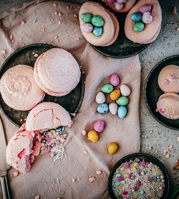 Vanille-Macarons, zartes Baiser-Gebäck mit Vanille-Ganache, als klassische Macarons, in Ei-Form mit Schoko-Eiern oder als Piñata-Macaron mit Streuseln darin / Vanilla macarons, classic, egg-shaped or as piñata with sprinkles [wienerbroed.com]